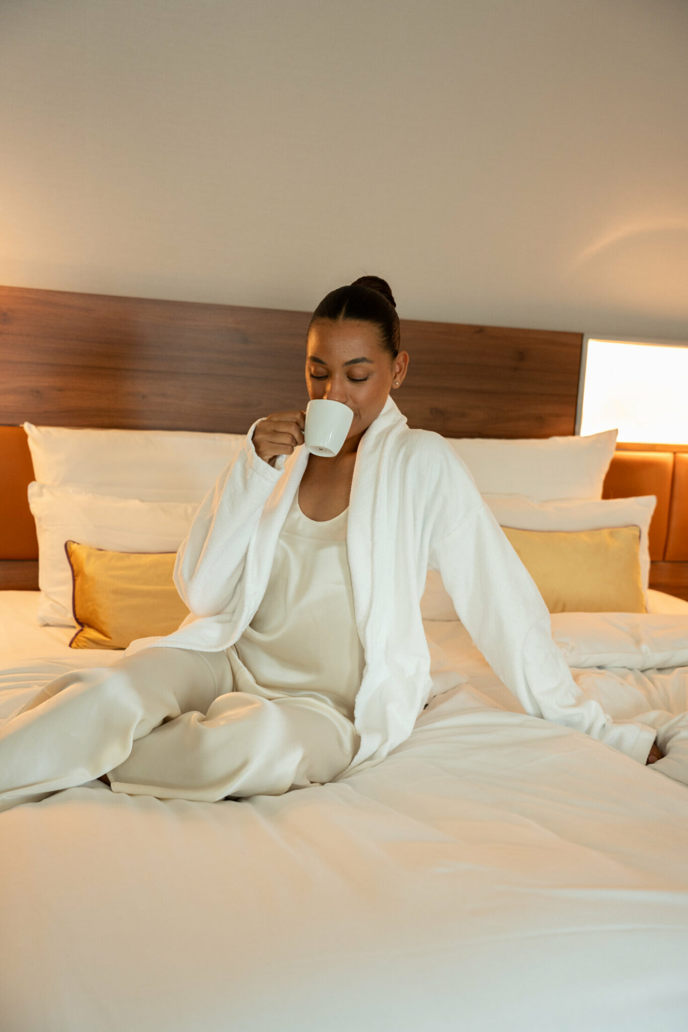 Frau genießt Kaffee im Bett im Reichshof Hamburg
