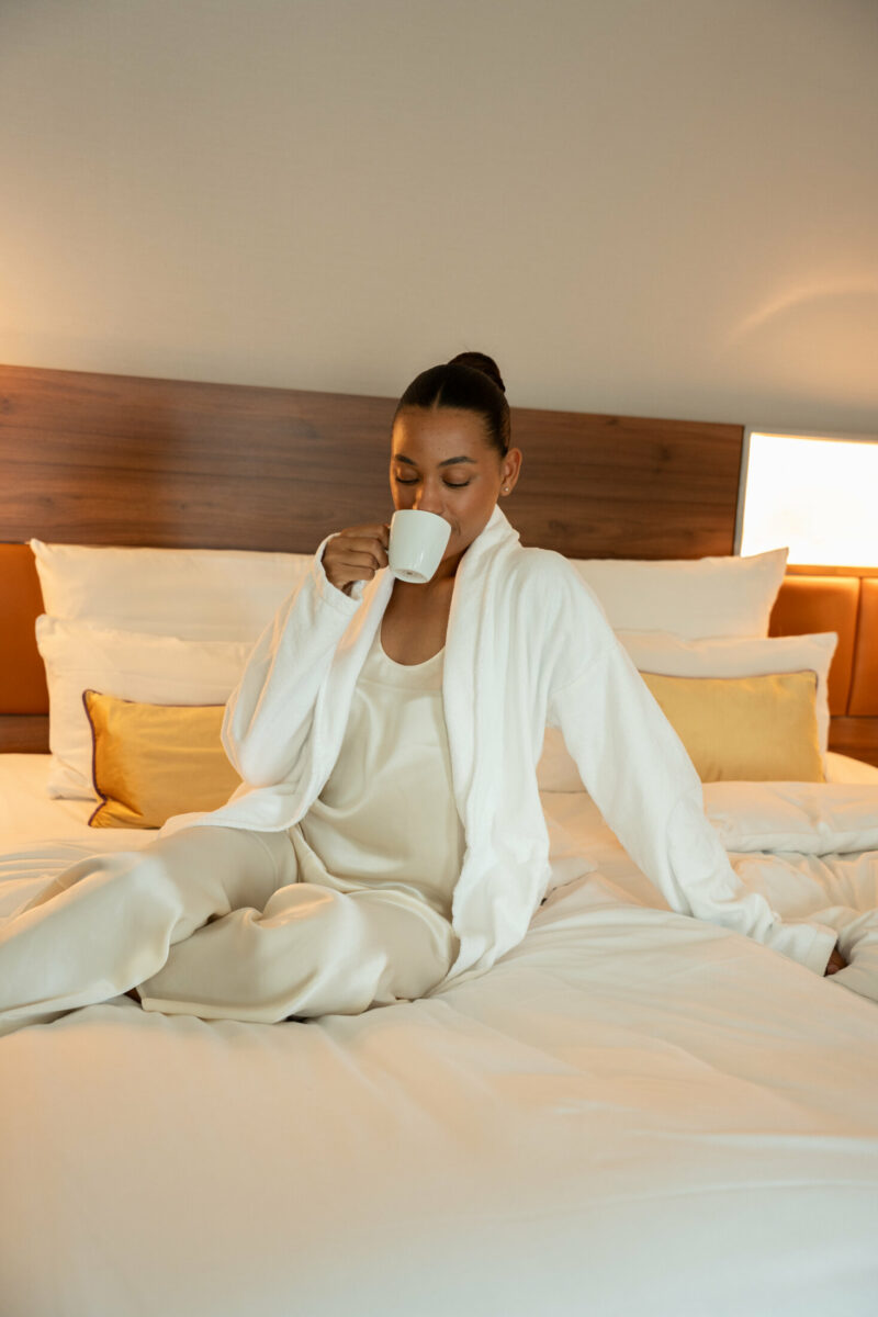 Frau genießt Kaffee im Bett im Reichshof Hamburg