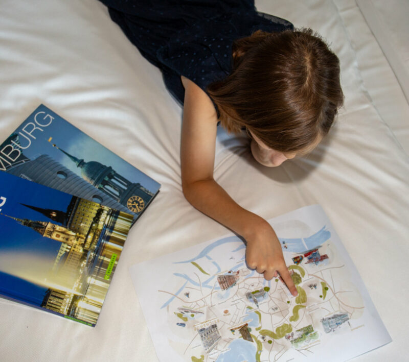 Child reading book on hotel bed