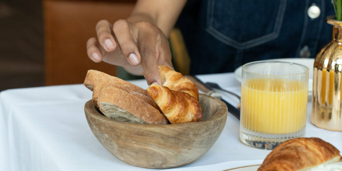Gast greift nach Croissant im EMIL'S