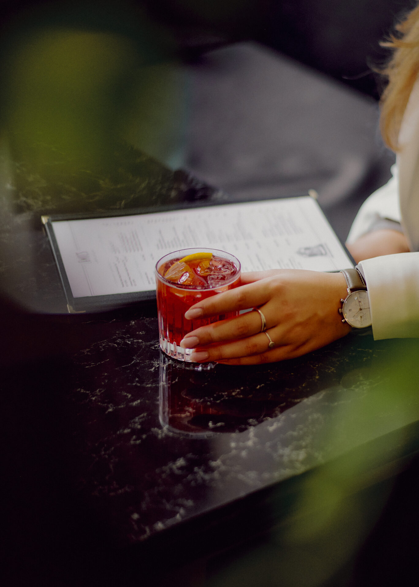 Closeup Gast mit Getränkekarte und Cocktail